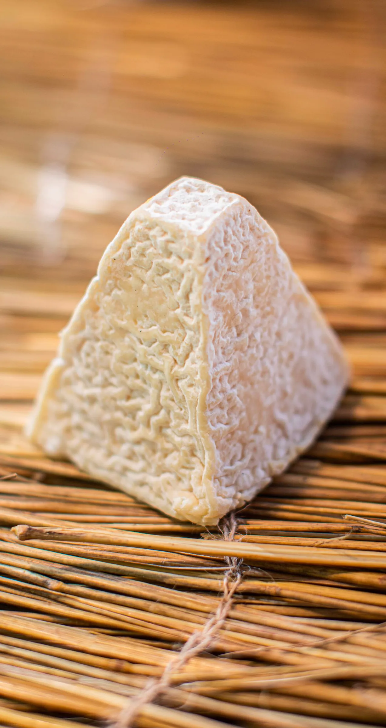 Pyramide de fromage de chèvre à croûte fleurie sur un lit de paille