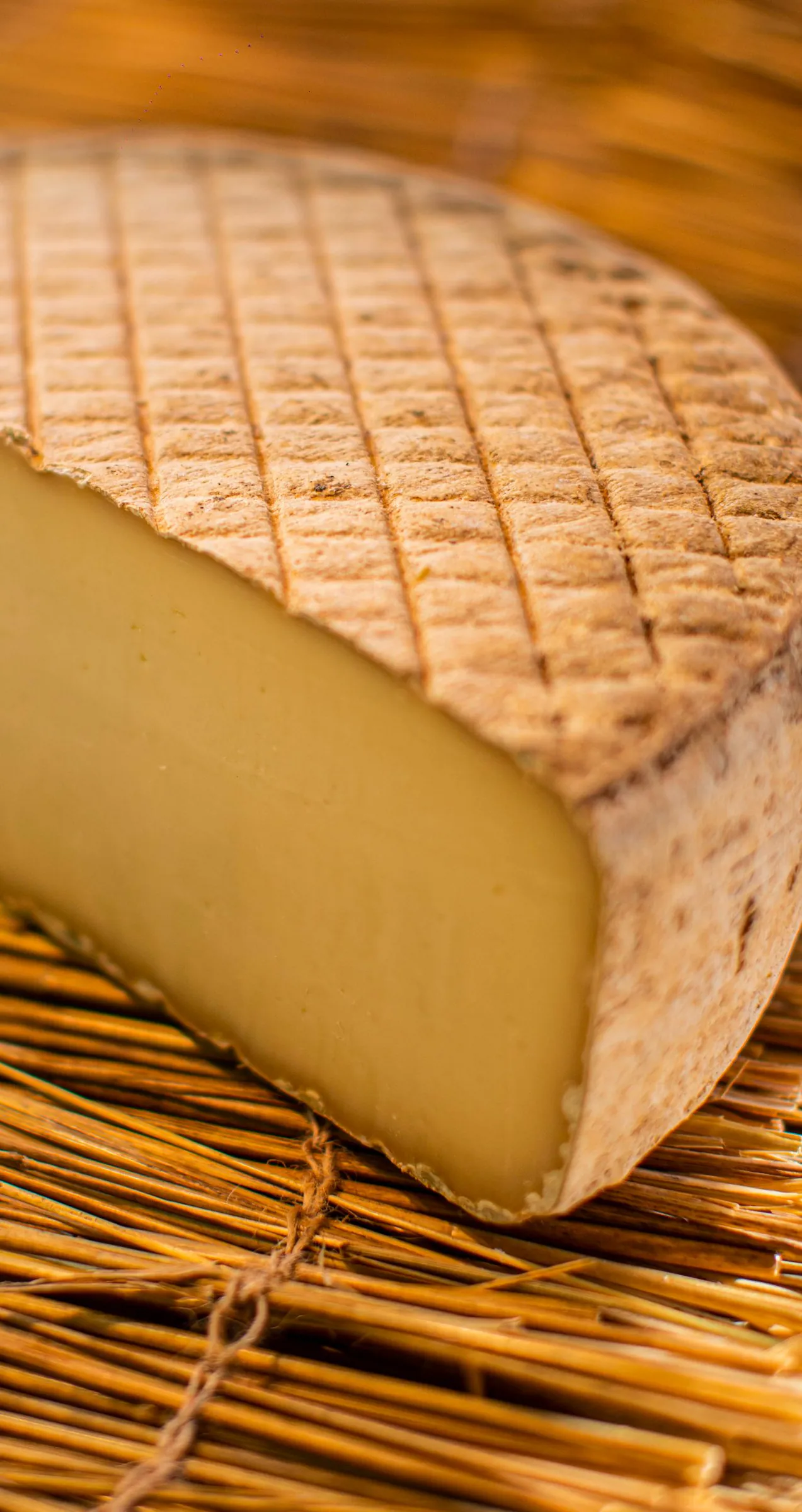 Tomme à croûte quadrillée, coupée, sur un lit de paille