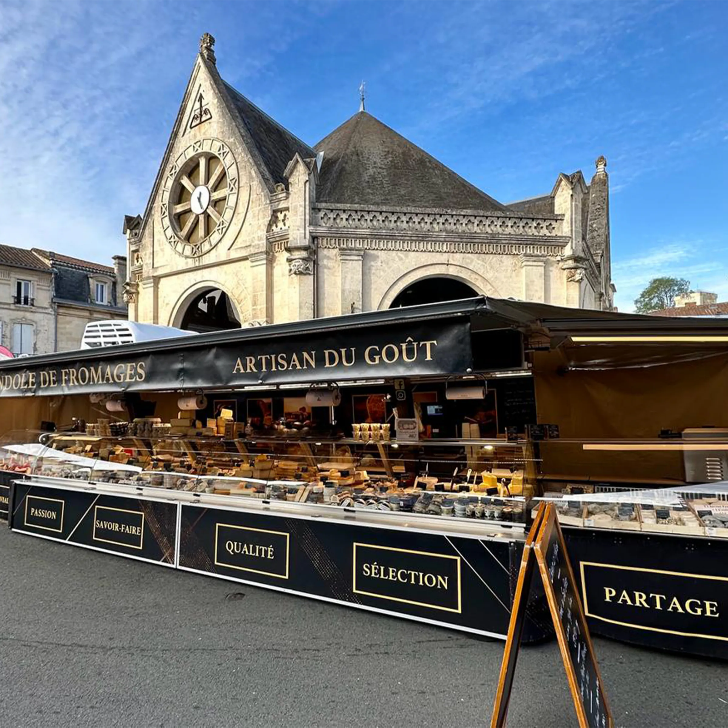Le stand de La Farandole de Fromages au marché, sous la halle, vitrines réfrigérées garnies de fromages